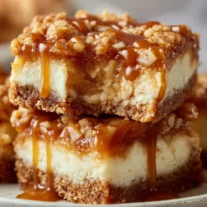 Delightful caramel apple cheesecake bars topped with caramel drizzle and apple slices.