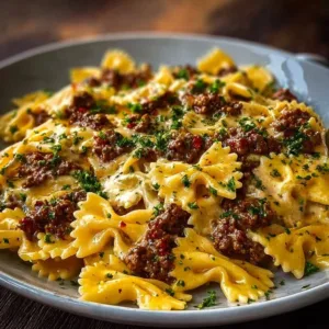 Cajun Cream Cheese Alfredo Bowties garnished with spiced ground beef
