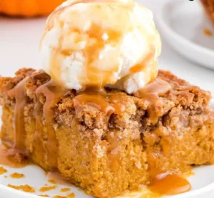 Delicious Pumpkin Spice Dump Cake topped with whipped cream and fall spices